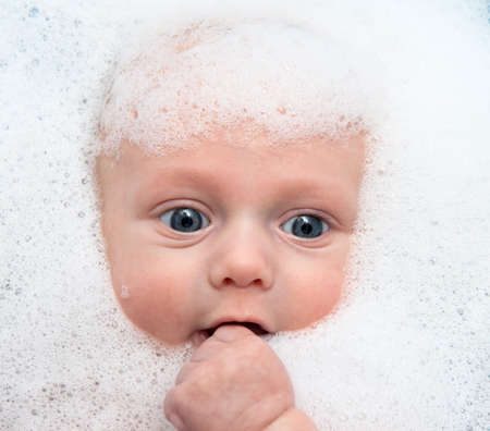 Baby boy in bath with soap foam
