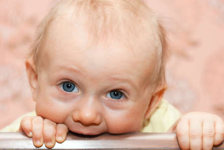 Baby boy gnaw a stick in bedの写真素材