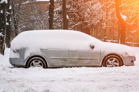 The car, covered with thick layer of snow. Negative consequence of heavy snowfalls. parked cars covered with snow during snowing in winter time
の写真素材