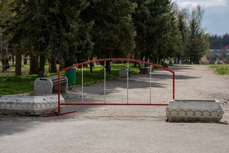 Red iron fence at the entrance to the Park for the period of the COVID-19 coronavirus pandemic.