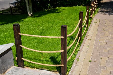 A small decorative fence . fence made from wooden poles and ropes.