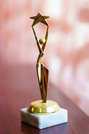 gold star trophy on wooden table.の写真素材