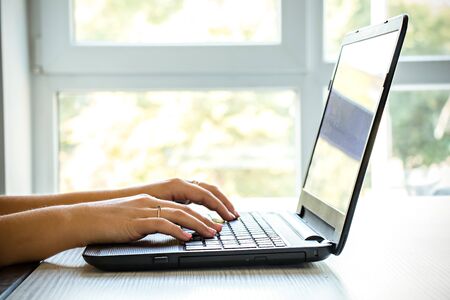 Closeup of business woman hands typing on laptop keyboard.