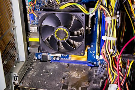 Dust on the computer pc processor cooler with mainboard and computer case fragment. Selective focus.