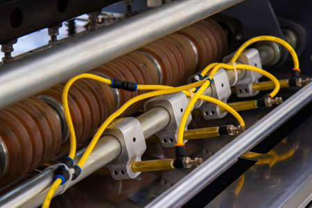 Part of an industrial machine tool in a factory . Many round wheels for pulling the sleeve for...