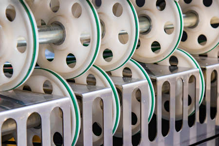 Part of an industrial machine tool in a factory . A lot of round plastic wheels for pulling the...