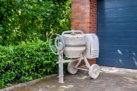 A white old concrete mixer near the garage entrance.の写真素材