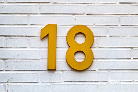 White brick wall with yellow sign on it that says'18 ' in Germanyの写真素材