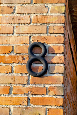 Brick wall with black number 8 on its side and brick wall behind it.