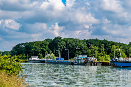 Large blue and white boat is docked at pier next to smaller boat.