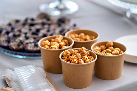 Close up of four cups of food on table with cake in the background.の写真素材