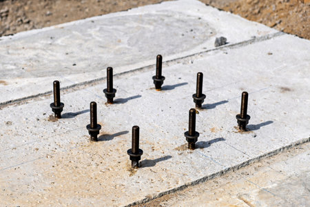 A concrete surface with a grid of metal bolts embedded in itの写真素材