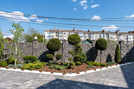 This is an image of a well-maintained garden area in front of a residential buildingの写真素材