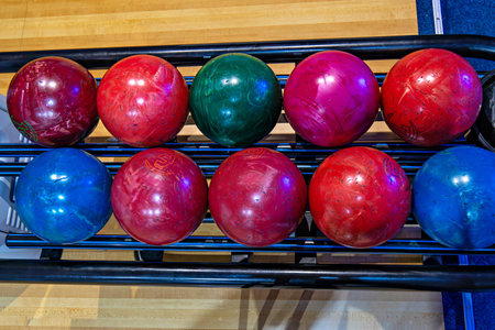 This image shows a set of ten bowling balls arranged on a rackの写真素材