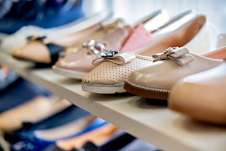 A collection of shoes on display with a variety of colors and styles including loafers and slip-ons arranged on shelvesの写真素材