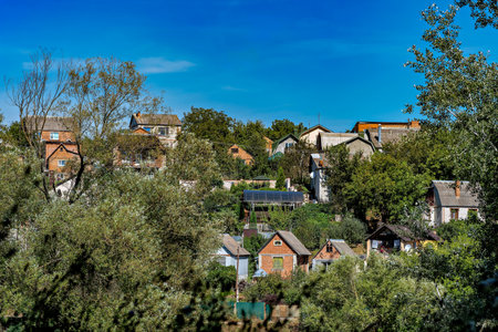 A picturesque village nestled in a valley with houses surrounded by lush greenery and treesの写真素材