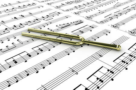 Gold tuning fork on a  background written notes