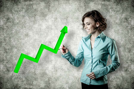 Smiling girl with a brush draws a green diagrammeの写真素材
