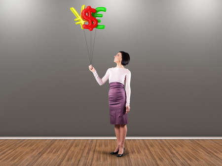 Girl with balloons in the form of moneyの写真素材