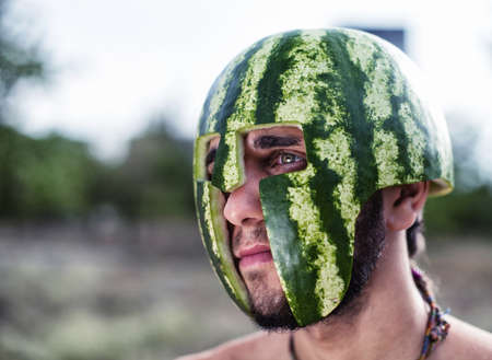 Photo of the young soldier with a water-melon on a headの写真素材