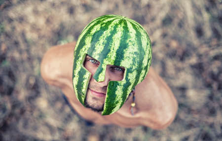 Photo of the young soldier with a water-melon on a headの写真素材