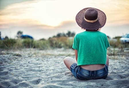 Girl sits on a beach near the seaの写真素材