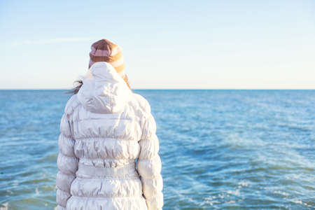A young girl stand alone on the beachの写真素材