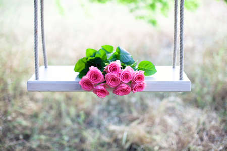 Beautiful pink flowers lying on a swingの写真素材