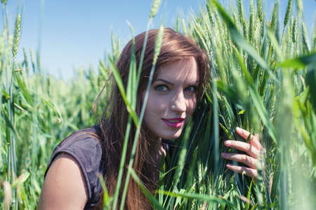 The beautiful girl is on a wheaten fieldの写真素材