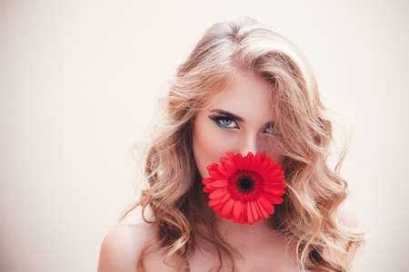 Beautiful girl with a nice flower in mouthの写真素材