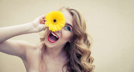 Beautiful girl with a nice flower in handの写真素材
