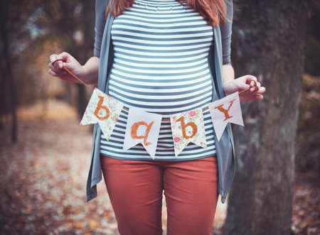 Beautiful pregnant woman with a big belly on outdoors