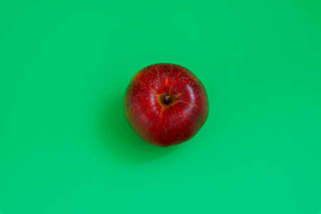 Bright juicy sweet red apples on a green background.
