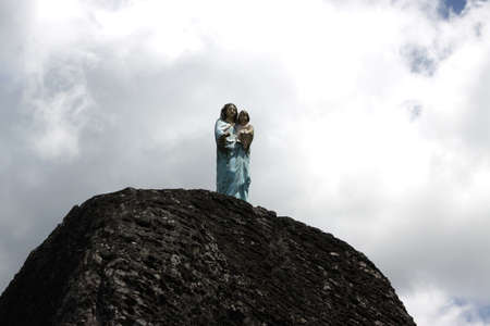 The sculpture of the virgin Mary on top of a mountainの写真素材