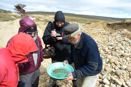 Gold digger shows tourists alluvial gold sand mined in the mine on the island of Tierra del Fuego.のeditorial素材