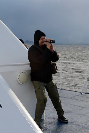Tourist on the deck of a ship at Cape horn in strong winds.のeditorial素材