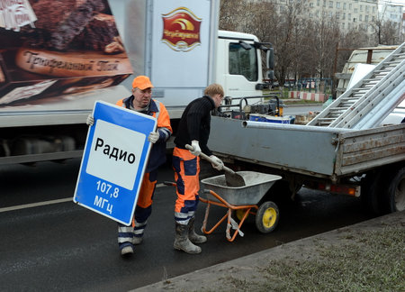 Workers install traffic sign on street of Moscow.のeditorial素材