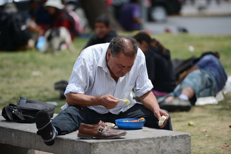 Homeless people with food from missionaries on the street of Santiago.のeditorial素材