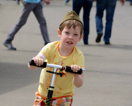 An unknown boy on a scooter at the celebration of the Victory Day at the All-Russian Exhibition Center in Moscow.のeditorial素材