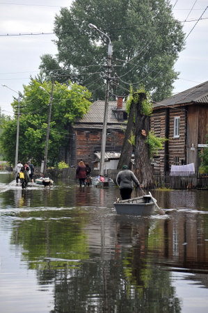 Local residents move around the streets during a flood. The Ob river, which came out of the banks, flooded the outskirts of the city.のeditorial素材