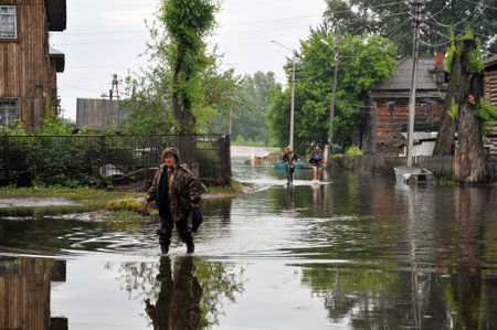 Local residents move around the streets during a flood. The Ob river, which came out of the banks, flooded the outskirts of the city.のeditorial素材