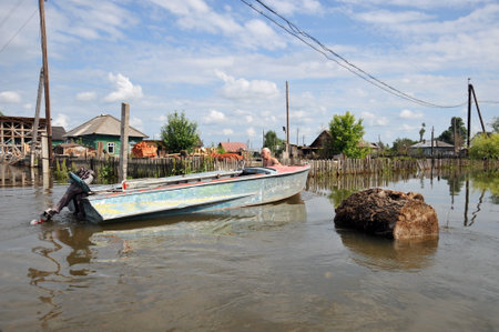 Locals move around the streets by boat. The Ob river, which came out of the banks, flooded the outskirts of the city.のeditorial素材