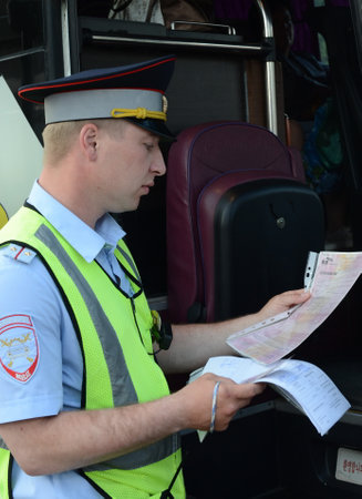 The inspector of the road police patrol checks documents from the driver of the intercity passenger...