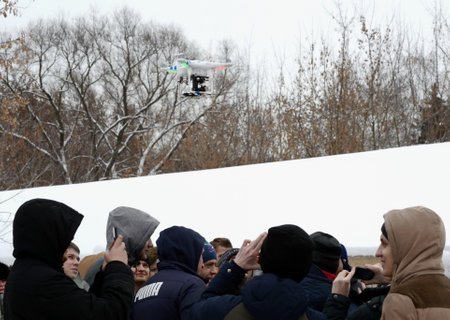 An unmanned aerial vehicle (UAV) is shooting people on the street.のeditorial素材