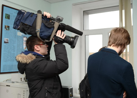 The cameraman holds a video camera on his head during the shooting.