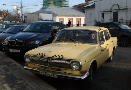The old car GAZ-24 "Volga" taxi yellow is on the street Varvarka in Moscow.のeditorial素材