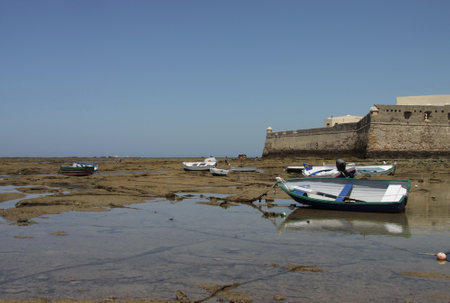Boats off the coast of Cadiz near the fortress of Castillo Fortaleza de Santa Catalina.のeditorial素材
