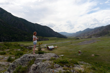 Tourists view the rock petroglyphs in the tract Kalbak-Tash. Altai republicのeditorial素材