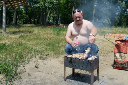An unidentified man prepares a kebab in a Moscow Parkのeditorial素材