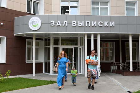 Young parents with a newborn baby come out of the discharge hall of the maternity hospitalのeditorial素材
